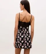 Camisón corto de microfibra con estampado floral, presenta un diseño con escote en V decorado con encaje negro y breteles finos ajustables.