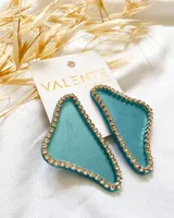 Par de aros colgantes con forma geométrica irregular, color celeste con borde dorado y strass.