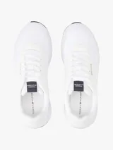 Zapatillas deportivas Tommy Hilfiger de corte bajo, color blanco, confeccionadas en tejido de punto de poliéster, con forro de poliéster, plantilla extraíble de poliuretano y suela de EVA. Presentan logo Hilfiger en relieve en el lateral y cinta distintiva en la entresuela.