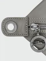 Bolso de mano Longchamp modelo Le Pliage Xtra L, color negro, confeccionado en cuero vacuno. Presenta un diseño estructurado con solapa frontal con botón a presión, doble asa superior y correa de hombro ajustable y extraíble con logo grabado.