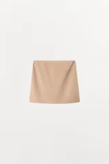 Falda mini de tiro bajo, confeccionada en tejido liso de color negro, con diseño minimalista y cintura elástica.