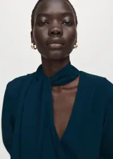 Vestido corto azul oscuro, de manga larga y escote en V, con detalle de bufanda integrada al cuello y fruncidos laterales en la falda.