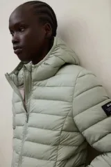Campera puffer con capucha, color verde, diseño acolchado con costuras horizontales y cierre frontal.