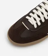 Championes de estilo retro inspirados en calzado de fútbol, confeccionados en poliuretano color verde menta con detalles laterales en rosado. Presentan suela plana de goma color caramelo y cierre mediante cordones al tono.