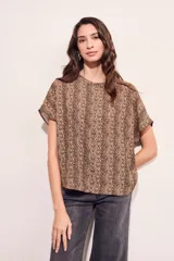 Blusa color beige con estampado animal print en marrón, de corte holgado y mangas cortas.