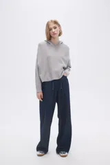Sweater gris melange medio con capucha y corte cropped.