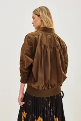 Campera bomber de corte holgado en color marrón, con cuello, puños y ruedo de tejido elástico acanalado. Presenta cierre frontal y diseño de mangas con volumen.