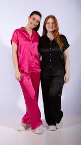 Camisa de manga corta con cuello camisero y botones nacarados. La tela es negra con un patrón de rayas verticales en relieve, con un acabado satinado.