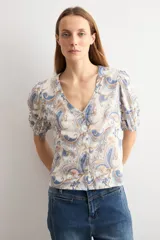 Camisa manga corta con estampado paisley en tonos azules y marrones, escote en V y cierre frontal con botones.