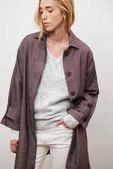 Spolverino color bordó con cuello camisero, botones frontales y mangas largas con puños anchos. Presenta costuras decorativas en contraste.