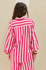 Camisa de corte oversize con estampado de rayas verticales en tonos fucsia y blanco, de manga larga abullonada y cierre frontal con botones.
