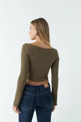 Top blanco de manga larga con cuello bote y corte crop.