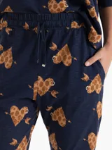 Babucha de tejido flammé color azul marino con estampado de corazones con textura animal print y flechas. Presenta cintura elastizada con cordón de ajuste y corte holgado.