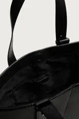 Bolso shopper de hombro en color negro, con diseño minimalista y liso. Cuenta con compartimento principal con cierre magnético y un bolsillo interior plano.