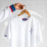 Remera blanca de algodón con cuello redondo y manga corta. Estampado pequeño en el pecho de un jugador de fútbol pateando la pelota.