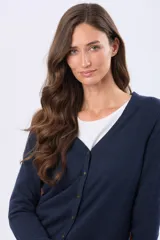 Saco tejido fino de hilo de algodón color beige, con cuello en V, cierre frontal con botones y puños acanalados.