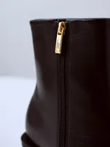 Bota de caña media confeccionada en cuero negro, con punta cuadrada y taco ancho de altura media.