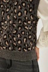Chaleco de punto con diseño de animal print de leopardo en tonos grises y negros, con cuello redondo y corte sin mangas.