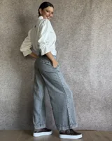 Pantalón de jean gris claro con corte palazzo y cintura alta.