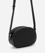 Cartera tipo camera bag pequeña, color marrón camel, de forma ovalada con superficie texturizada. Cuenta con correa ajustable larga, cierre principal con cremallera dorada y un pequeño bolsillo frontal con cremallera.