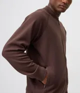 Campera bomber de fleece color marrón, con cierre frontal, cuello tipo tirilla, mangas largas y bolsillos laterales con cierre.