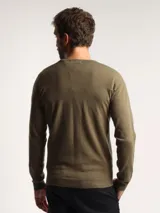 Sweater de punto con cuello en V, manga larga y puños acanalados, de corte clásico.