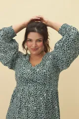 Vestido corto con estampado animal print en tonos verde y blanco, escote en V y mangas 3/4 acampanadas.