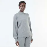 Sweater de punto acanalado en color gris, con cuello alto y mangas largas con diseño ligeramente abullonado.