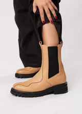 Bota de cuero color camel, estilo Chelsea, con elásticos laterales negros y suela track negra.