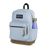 Mochila JanSport Right Pack color celeste con base de gamuza marrón, compartimento interno para laptop, bolsillo frontal con cierre y tiradores de cuero.