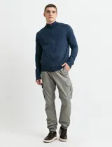 Pantalon cargo de corte ajustado en color verde grisáceo, con bolsillos laterales con solapa y puños elásticos en los tobillos.