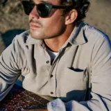 Camisa de pana color beige, de corte recto, manga larga y cuello clásico.