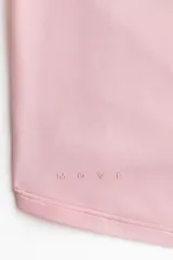 Top cropped de yoga de punto modal suave en color rosado, con mangas largas, escote en V pronunciado y diseño cruzado con tira para anudar al frente.