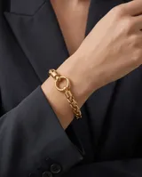 Pulsera de eslabones trenzados en acero con baño de oro, con cierre circular frontal tipo mosquetón.
