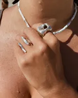 Anillo dorado con forma irregular y un agujero en el centro.