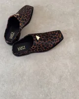 Suecos con estampado animal print en tonos marrones y negros, con detalle de triángulo dorado en el empeine.