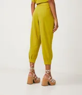 Pantalón jogger color naranja, de tiro medio, con cintura elastizada, lazo ajustable, pliegues delanteros y bolsillos laterales.