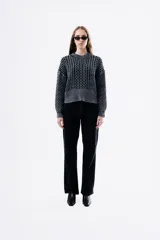 Sweater de punto grueso con textura marcada, de silueta relajada y diseño amplio, con cuello redondo y puños acanalados.