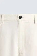 Pantalón chino de corte recto confeccionado en algodón. Presenta bolsillos frontales, un pequeño bolsillo cerillero y bolsillos traseros de vivo con botón. Cierre frontal con cremallera y botón.
