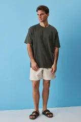 Short de gabardina color beige con calce relajado, cintura elástica con cordón ajustable y largo a mitad de muslo.