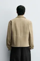 Cazadora regular fit de piel con acabado ante napado, color beige. Sin forro interior, cuello solapa, manga larga, bolsillos de vivo en cadera y cierre frontal con cremallera.