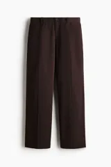 Pantalón sastrero color marrón oscuro, de corte relajado y piernas con pliegues, confeccionado en mezcla de algodón y lyocell. Cuenta con cierre y botón, bolsillos laterales y bolsillos traseros insertados con botón oculto.