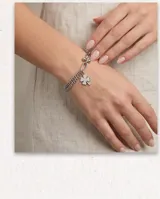 Pulsera de plata con diseño de cadena múltiple y dije colgante en forma de trébol de cuatro hojas.