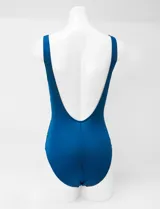 Malla enteriza estampada con diseño geométrico multicolor que degrada a azul en la parte inferior, con escote cuadrado y tirantes anchos.