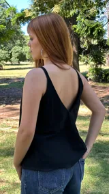 Blusa negra de tirantes finos con escote en V pronunciado en la espalda.