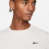 Buzo color crema de algodón y poliéster con textura tipo waffle, corte holgado, cuello redondo y logo Nike bordado en el pecho.