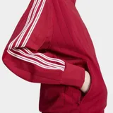 Campera deportiva Adidas Pinstripe Firebird de color rojo con detalles de rayas verticales sutiles y las clásicas tres tiras blancas en las mangas. Cuenta con cuello alto, cierre frontal completo y bolsillos laterales.