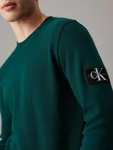 Remera verde de manga larga con cuello redondo y logo de Calvin Klein en el brazo. Corte slim.