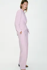 Pantalón de tiro alto color rosado, con pernera recta, bolsillos delanteros y cierre frontal con cremallera, botón interior y gancho.