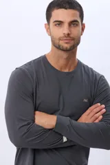 Remera de manga larga color gris oscuro, con escote redondo y logo bordado en el pecho.